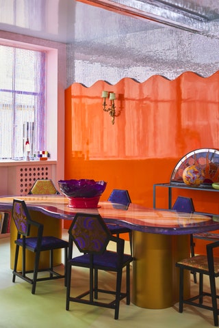 mirrored mosaic ceiling extending partway down wall shiny orange color covers rest of wall reflective dining table...