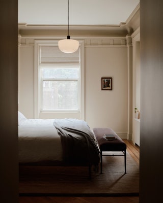 The primary bedroom embraces a modern aesthetic. Lee painted the walls with Benjamin Moores Finnie Gray and kept the...