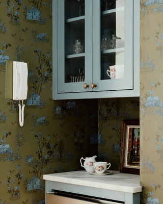 The kitchens two zones connect via a beverage station embellished with woodlandthemed toile wallpaper from British...