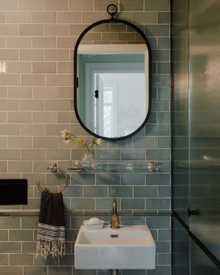 Simplicity reigns in the daughters bathroom with its gray floortoceiling tile from Waterworks. A pillshaped mirror ...